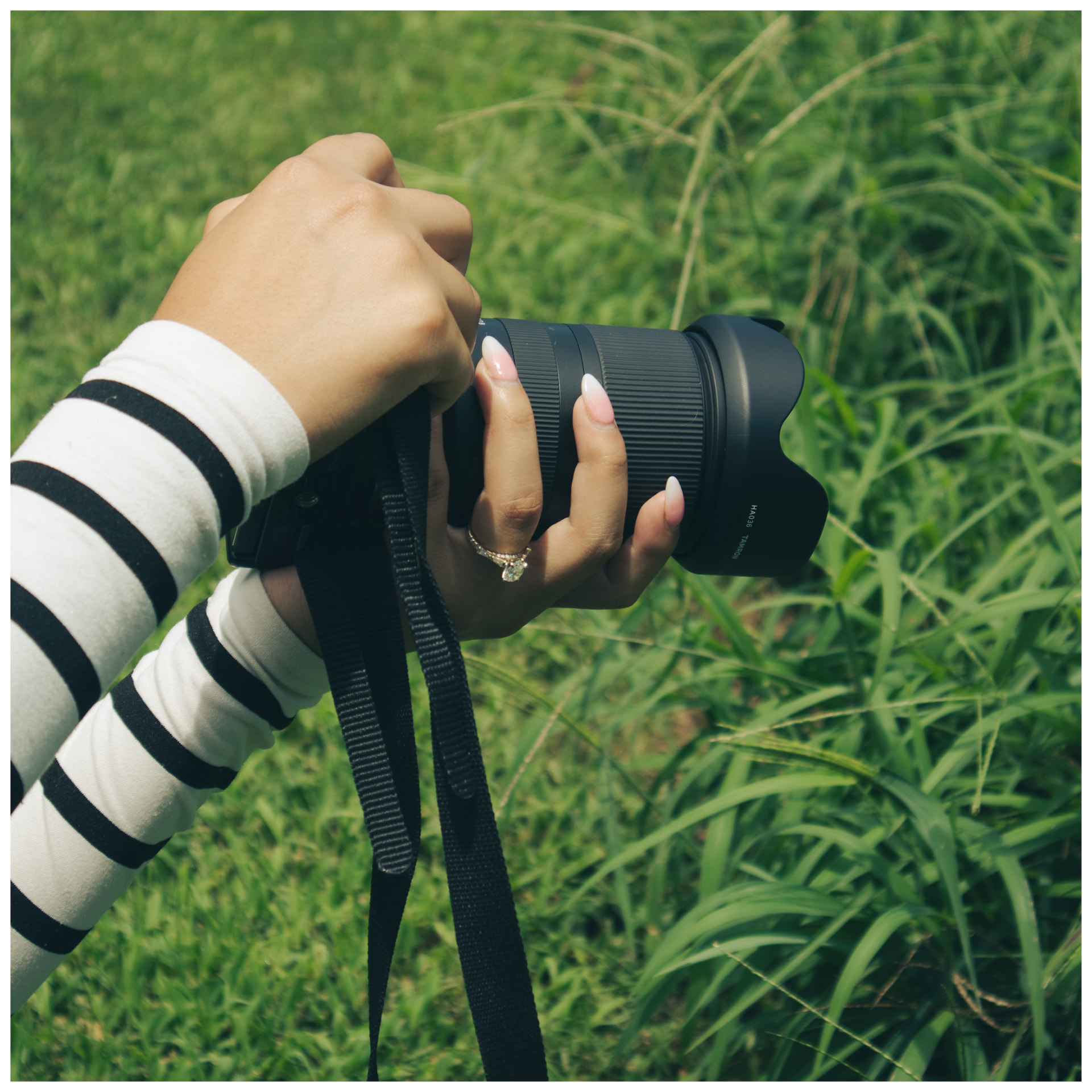 Jenny holding her camera in tall grass