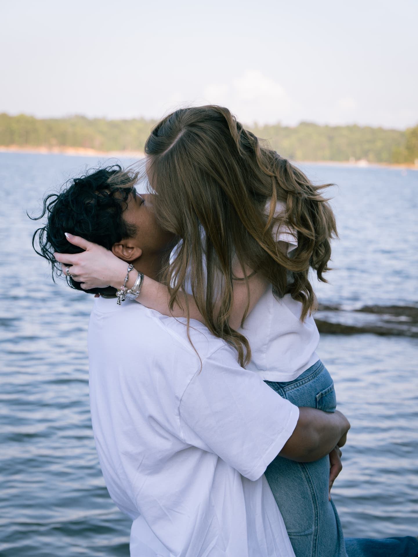 Couple embracing and kissing beside the lake in North Georgia