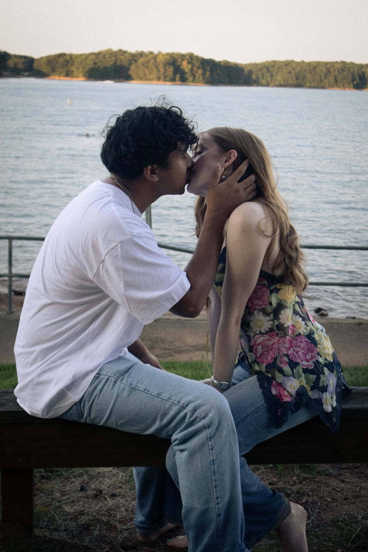Couple kissing on a bench overlooking the lake at sunset in North Georgia