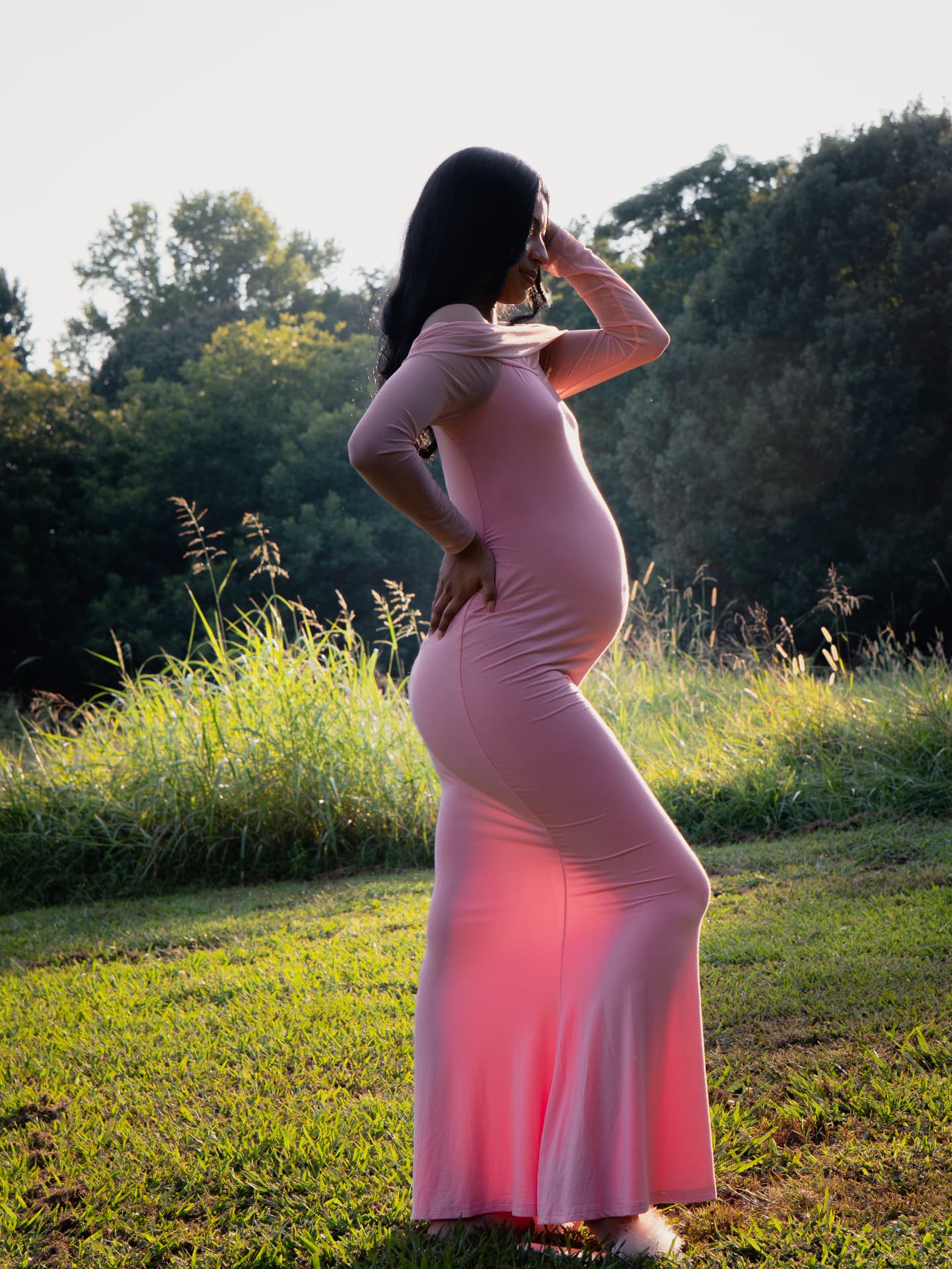 Backlit maternity portrait in a pink gown at sunset in North Georgia