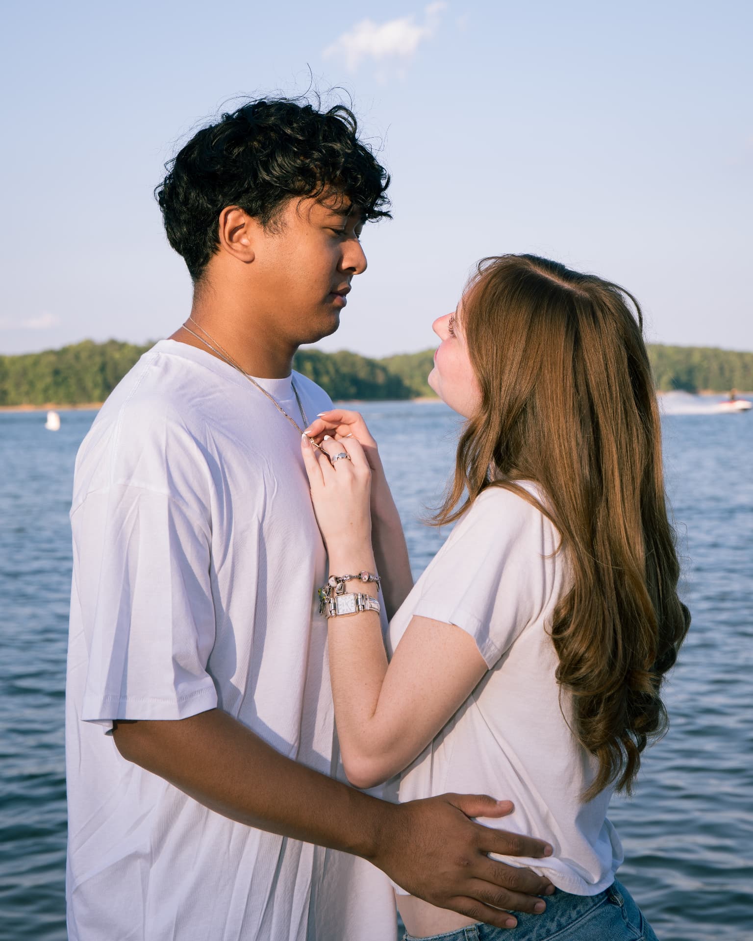 Couple looking at each other by the lake during a golden hour couples session