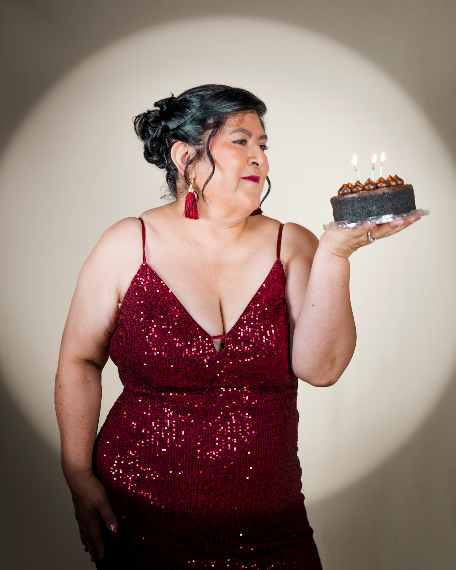 Full-length studio portrait with birthday cake in spotlight