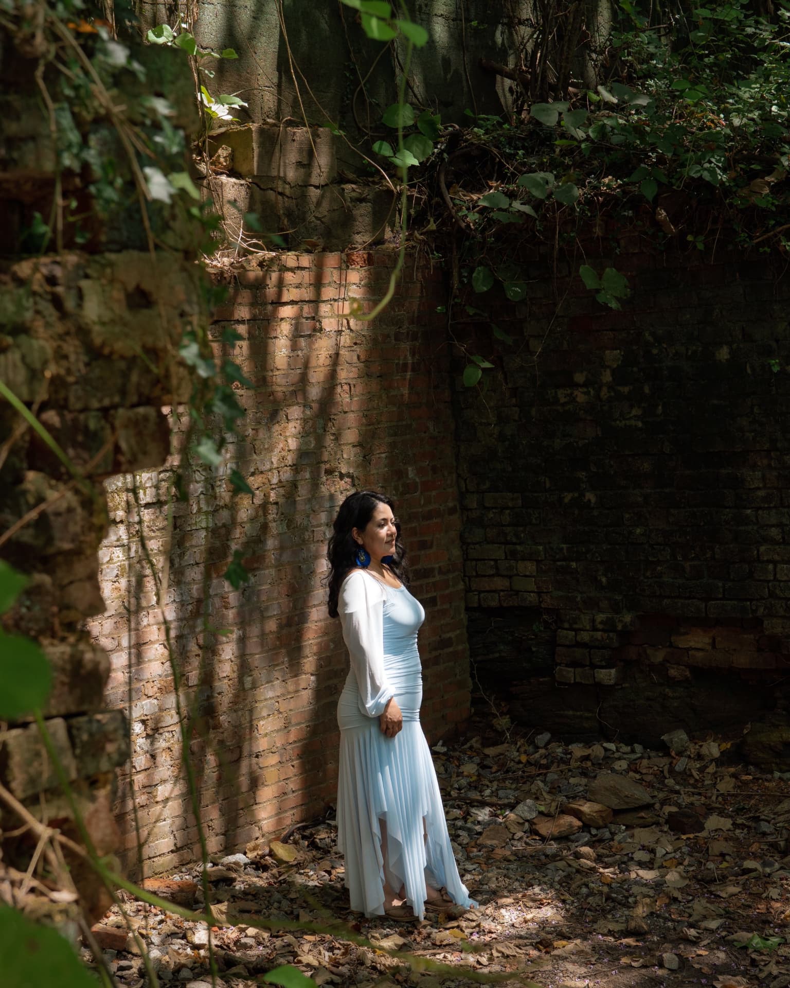 Woman in a blue gown standing among ivy-covered brick ruins in North Georgia