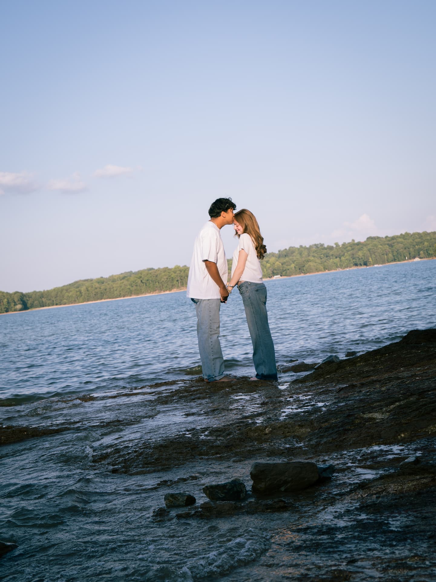 Couple holding hands at the water's edge at Lake Lanier in North Georgia
