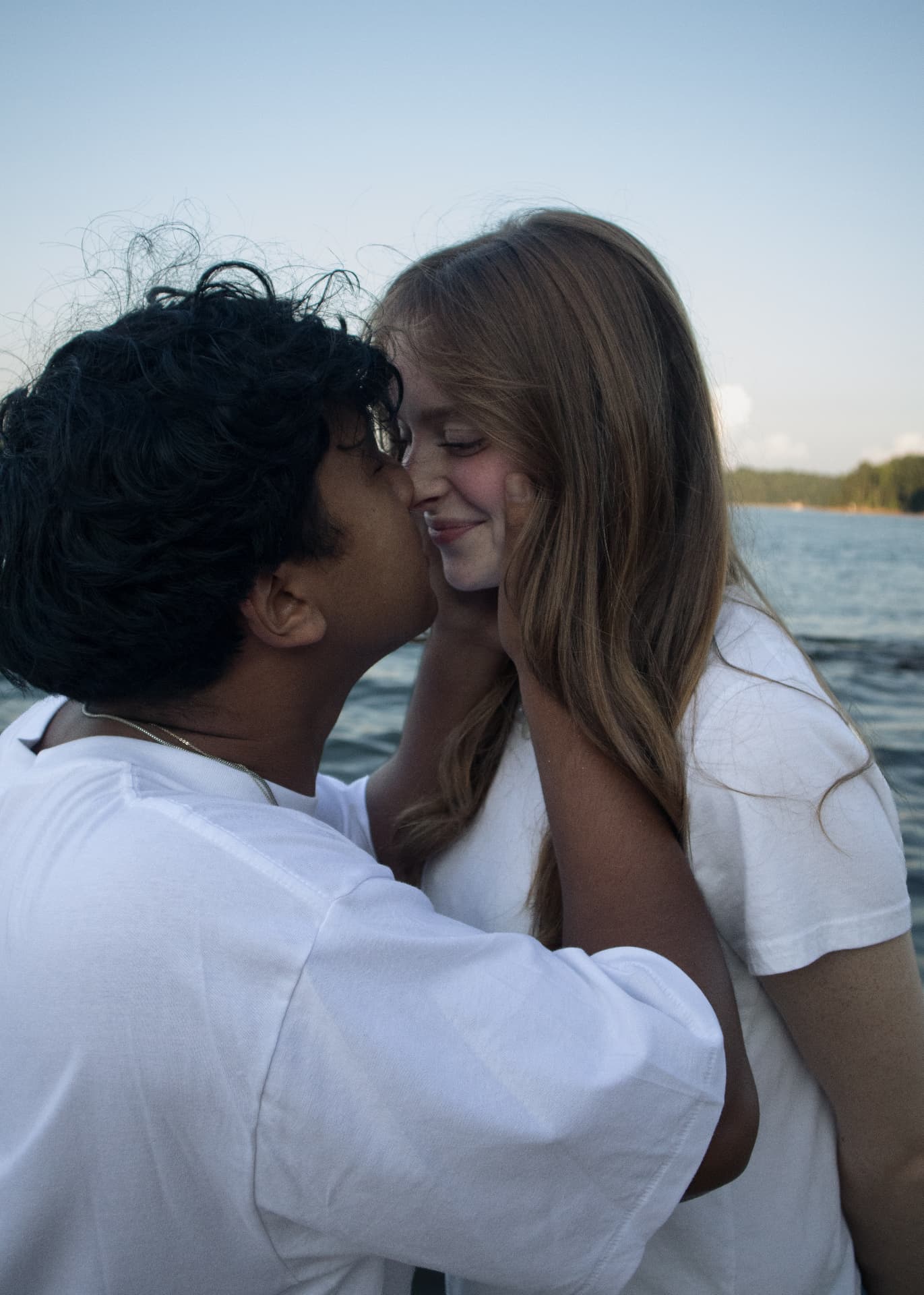 Man kissing his smiling partner's cheek beside the lake in North Georgia